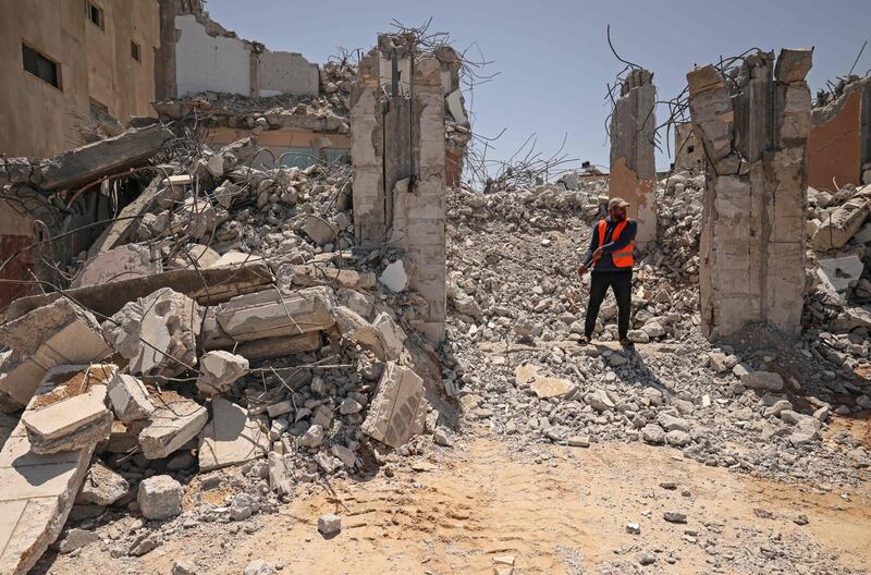 A Palestinian worker clears the rubble of a destroyed building on the first anniversary of the May 2021 conflict between Israel and Hamas in Gaza city. AFP