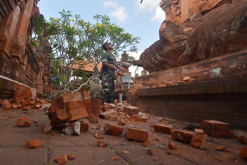 An Indonesian soldier looks at a Hindu temple damaged following an earthquake in Denpasar, Bali, Indonesia, July 16, 2019 in this photo taken by Antara Foto.  Antara Foto/Nyoman Budhiana/ via REUTERS  ATTENTION EDITORS - THIS IMAGE WAS PROVIDED BY A THIRD PARTY. MANDATORY CREDIT. INDONESIA OUT.