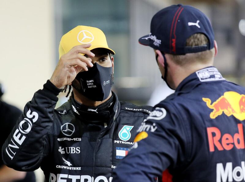 Third-placed qualifier Lewis Hamilton of Mercedes GP speaks with pole position qualifier Max Verstappen of Red Bull Racing. Reuters