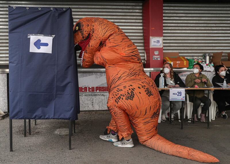 A person dressed as a dinosaur votes during the second day of the Constitutional Convention election in Santiago, Chile. AP Photo