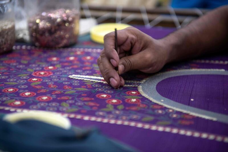 In this photo taken on February 14, 2020, a man works on an embroidery at the factory of fashion deisgner Anita Dongre on the outskirts of Mumbai. With stores in India and New York, multiple clothing brands and a global celebrity following, fashion designer Anita Dongre is a feminist powerhouse in a male-dominated industry. But her true ambition is to create an environmentally sustainable company, she says. - TO GO WITH Women-activism-India-fashion-economy-environment,INTERVIEW by Ammu Kannampilly
 / AFP / Laurène Becquart / TO GO WITH Women-activism-India-fashion-economy-environment,INTERVIEW by Ammu Kannampilly

