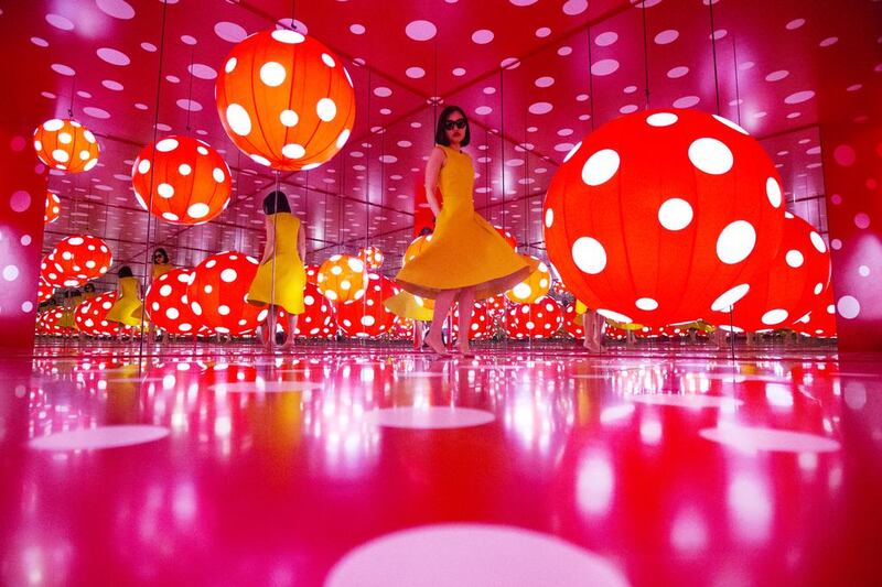 A visitor spins inside the Dot Obsessions installation by Japanese artist Yayoi Kusama at Sharjah Art Foundation in January. Christopher Pike / The National