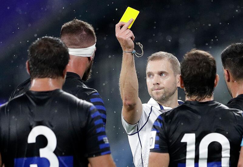 Argentina's Marcos Kremer, second left, is shown a yellow card by referee Angus Gardner. AP