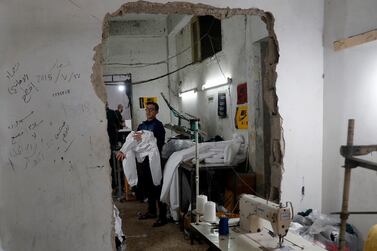 A palestinian checks a protective overall made to help shield people from the coronavirus, that will be exported to Israel, at a local factory, in Gaza City, Monday, March 30, 2020. (AP Photo/Adel Hana)