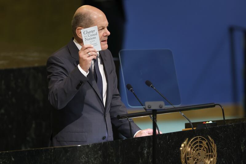 German Chancellor Olaf Scholz holds up a copy of the UN Charter. AFP