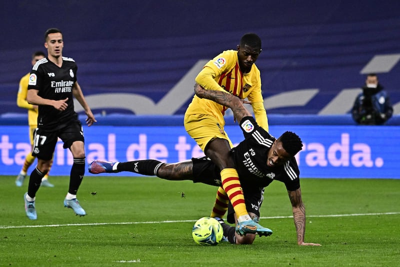 Real Madrid defender Eder Militao attempts to tackle Barcelona forward Ousmane Dembele. AFP