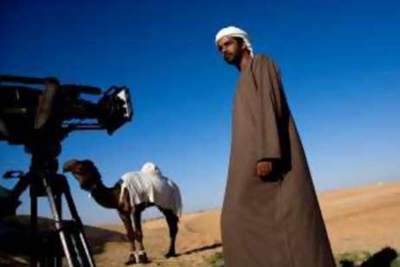 December 24, 2008 / Abu Dhabi / Fadel Al Muhairi (CQ) a filmmaker poses for his portrait while working on a film at the Dhafra Camel Festival 2009 in Madinat Zayed, Wednesday, December 24, 2008. Muhairi's documentary film focuses on the role the camel has taken in the bedouin culture of the Emirati. (Rich-Joseph Facun / The National) *** Local Caption ***  rjf-1224-camelfilm003.jpg