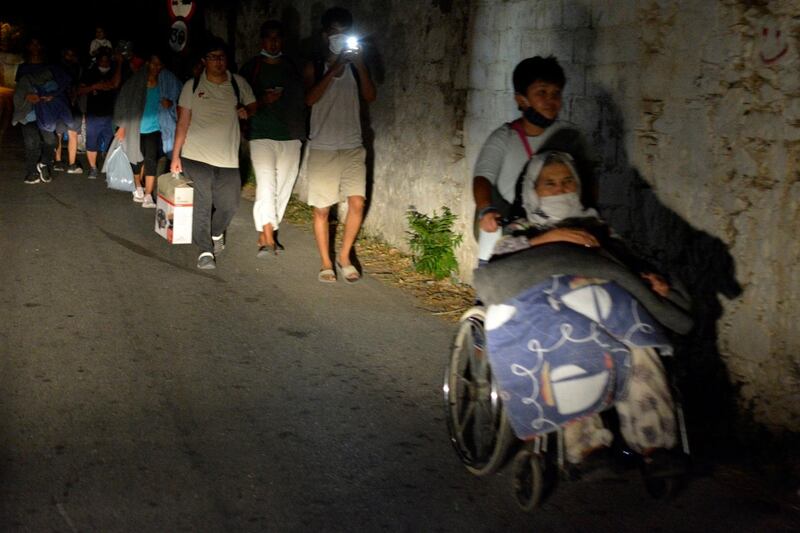 Refugees and migrants leave as a fire burns at the Moria refugee camp on the northeastern Aegean island of Lesbos, Greece. AP Photo