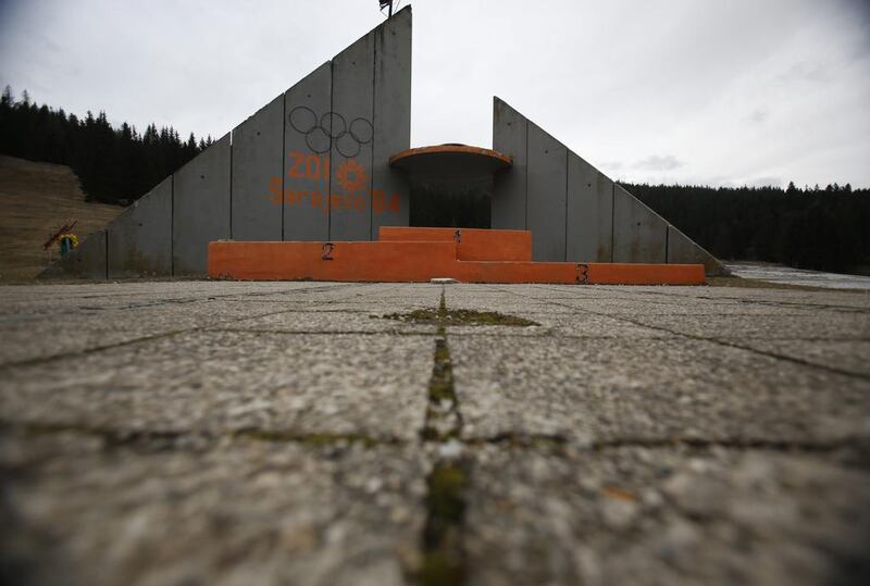 In this picture taken February 21, 2014, a concrete podium for winners with the text “Winter Olympic Games 1984” stands abandoned near jumping hills at Mt. Igman near the Bosnian capital of Sarajevo. Wartime destruction and negligence have turned most of Sarajevo’s 1984 Winter Olympic venues into painful reminders of the city’s golden times. The world came together in the former Yugoslavia in 1984 after the West had boycotted the 1980 Olympics in Moscow and Russia boycotted the 1984 Summer Games in Los Angeles. Just eight years later, the bobsleigh and luge track on Mount Trbevic was turned into an artillery position from which Bosnian Serbs pounded the city for almost four years. Today, the abandoned concrete construction looks like a skeleton littered with graffiti. Amel Emric / AP Photo