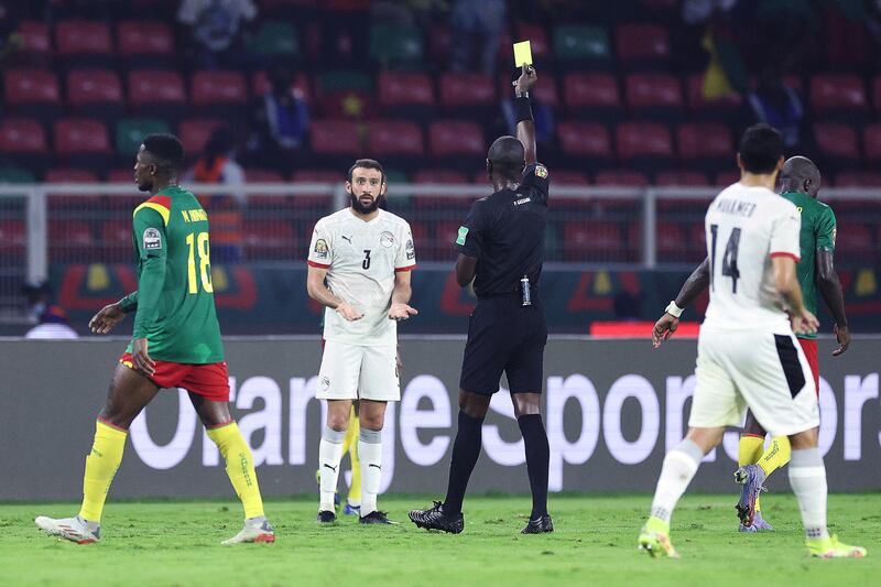 Egypt defender Omar Kamal is booked by Gambian referee Bakary Gassama. AFP