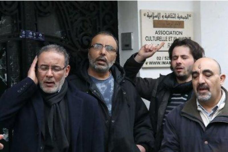 Men pray outside Al Rida mosque in the Anderlecht neighborhood of Brussels yesterday. The mosque's imam died of smoke inhalation following an arson attack on Monday.