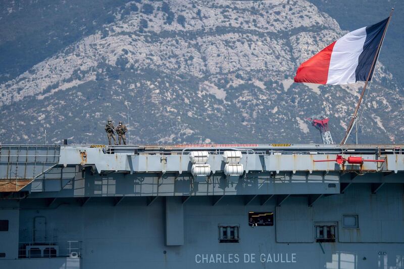 TOPSHOT - French navy soldiers wearing face masks stand onboard the French aircraft carrier Charles de Gaulle on April 12, 2020, as it arrives in the southern French port of Toulon with sailors onboard infected with COVID-19 (novel coronavirus). Fifty sailors aboard the Charles de Gaulle aircraft carrier, the flagship of the French navy, have contracted the novel coronavirus the armed forces ministry said on April 11. The nuclear-powered ship arrived in Toulon on April 12 so that those infected can begin a period of quarantine on dry land, according to the ministry.

 / AFP / Christophe SIMON

