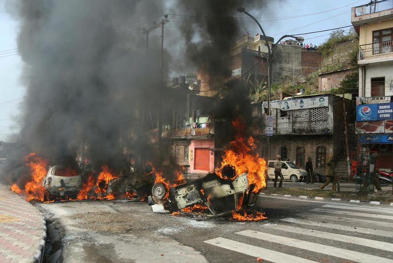 Vehicles are set on by a mob during a protest against Thursday's attack on a paramilitary convoy, in Jammu, India. AP Photo