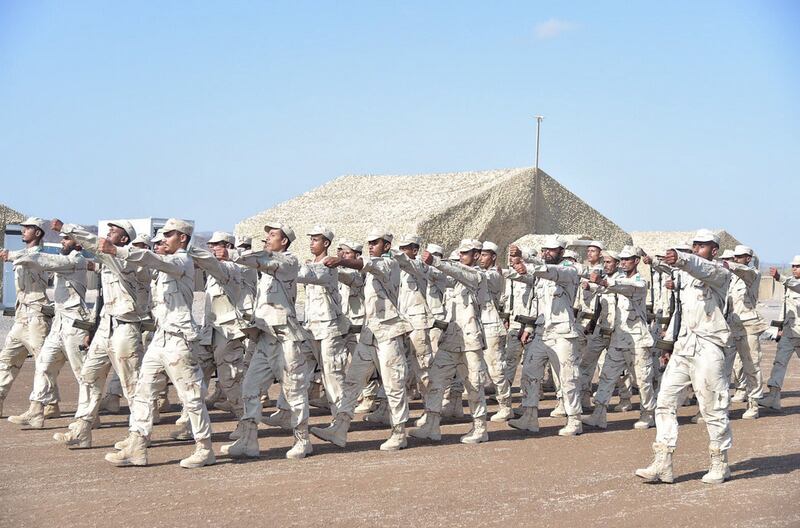 A graduate shakes hands with officers from the UAE and Yemen armies.