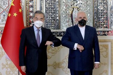 Iranian Foreign Minister Mohammad Javad Zarif, right, and his Chinese counterpart Wang Yi, pose for photos at the start of their meeting in Tehran, Iran.  AP