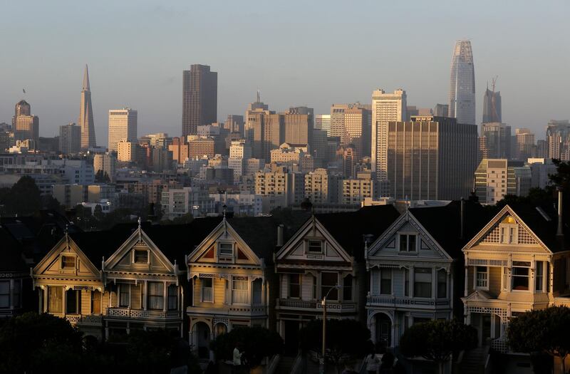 FILE - This July 11, 2017, file photo, shows the skyline beyond a row of Victorian houses in San Francisco. A San Francisco couple has agreed to a $2.25 million legal settlement to the city for illegally renting out 14 apartments as Airbnb units. The San Francisco Chronicle reported Monday, Nov. 5, 2018, that a couple has agreed to pay the sum as penalties and investigation costs. San Francisco requires people renting their homes through sites like Airbnb to live in them at least 275 nights a year and rent them no more than 90 days during that time. (AP Photo/Eric Risberg, File)