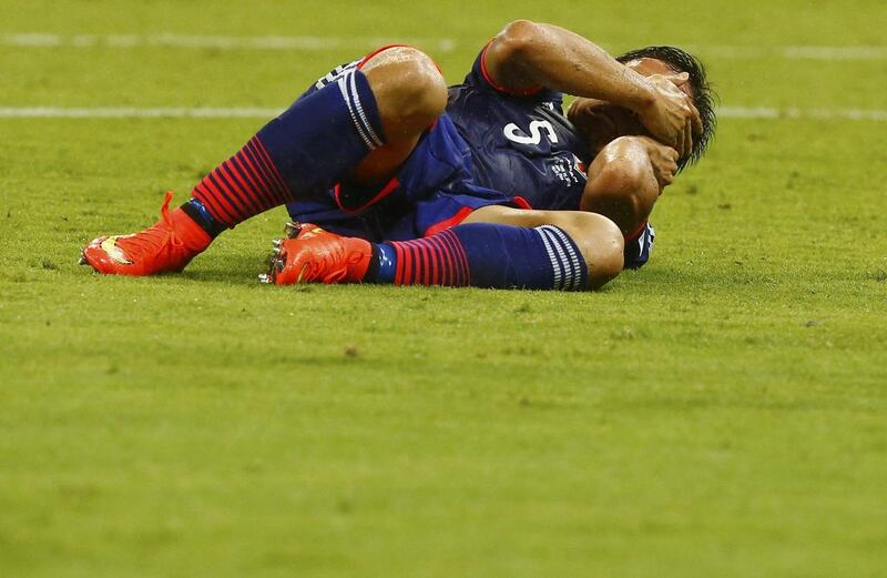 Japan’s Yuto Nagatomo lies injured on the ground. Stefano Rellandini / Reuters