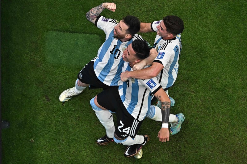 Argentina midfielder Enzo Fernandez, centre, celebrates scoring his team's second goal with Lionel Messi, left. AFP