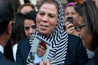 Latifa Ibn Ziaten shows a photograph of her son killed by Mohamed Merah, to France's President Francois Hollande. AFP