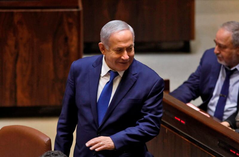 Israeli Prime Minister Benjamin Netanyahu stands next to Israel's former defence minister Avigdor Lieberman during a Knesset (parliament) session in Jerusalem on December 26, 2108. Israeli lawmakers gave initial approval to a bill to dissolve parliament and hold early elections on April 9 and it was expected to be finalised later in the evening. / AFP / Menahem KAHANA
