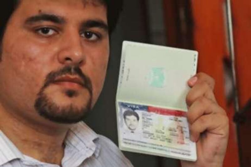 Zuhair Abu Shaban displays his Palestinian passport, stamped with a visa from the United States, which was later revoked, in Gaza.