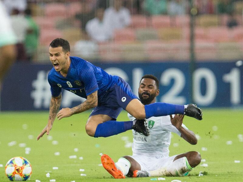 Ahli's defender Mohammed Khubrani (R) tackles Hilal's forward Sebastian Giovinco during the AFC Champions League play-off football match between Saudi's al-Ahli and al-Hilal at King Abdullah Sports CIty Stadium in the city of Jeddah on August 6, 2019. (Photo by - / AFP)