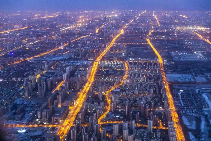 Arterial roads are lit up as morning commuters drive along at dawn in western Beijing. AFP