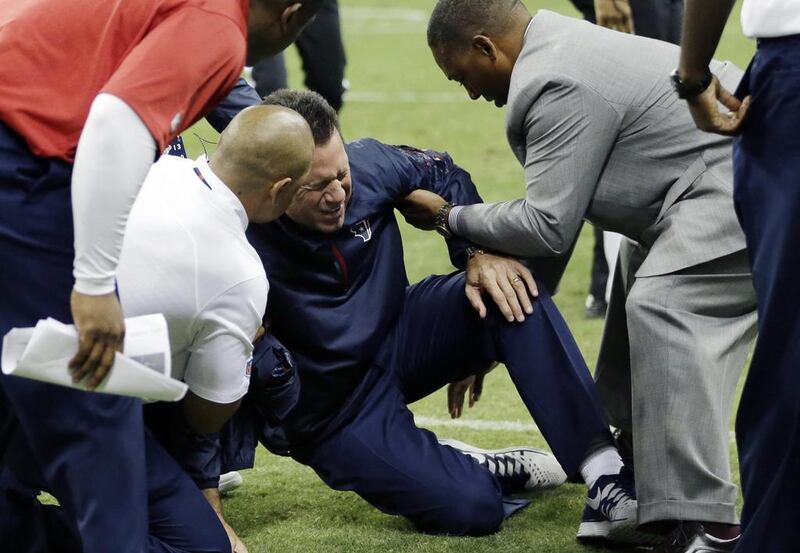 Houston Texans head coach Gary Kubiak, centre, is helped after he collapsed on the field during the second quarter of an NFL football game against the Indianapolis Colts last Sunday. David J. Phillip / AP Photo