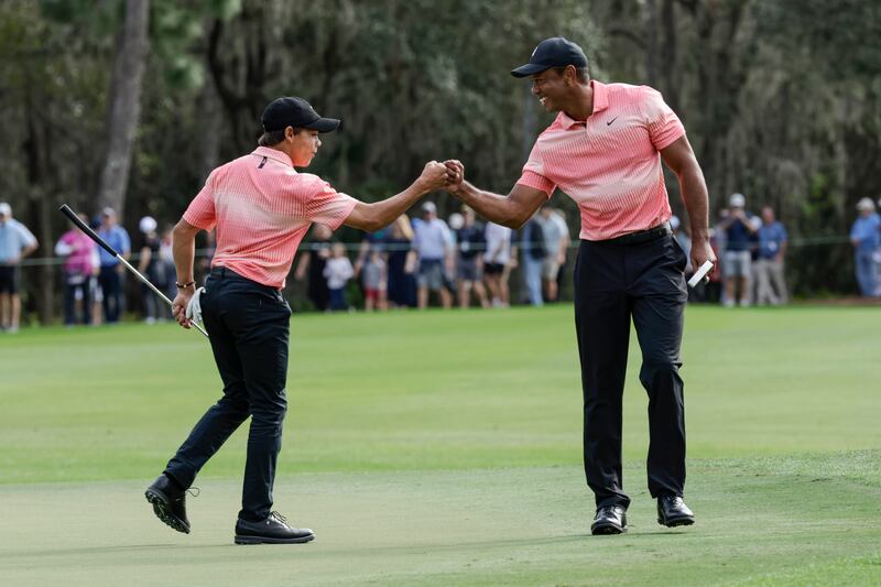 Tiger Woods, right and his son Charlie Woods bump fists on the ninth green during the first round of the PNC Championship golf tournament Saturday, Dec.  17, 2022, in Orlando, Fla.  (AP Photo / Kevin Kolczynski)