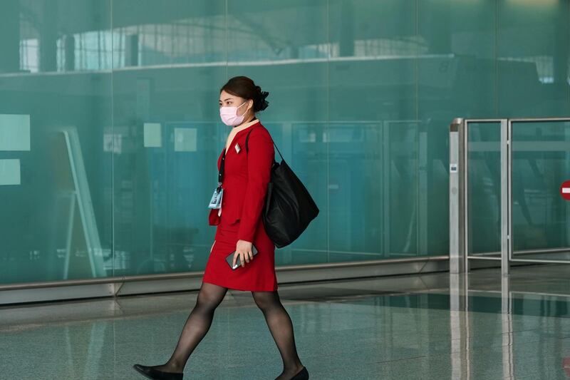 A Cathay Pacific employee, wearing a face mask to protect against the coronavirus, walks past the departures hall at Hong Kong International Airport in Hong Kong, China. Reuters