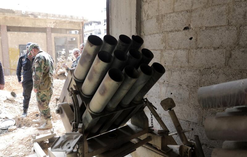 A Syrian soldier inspects weapons and ammunition at a room, in Zamalka town, Eastern Ghouta, in the countryside of Damascus on April 8, 2018. Youssef Badawi / EPA