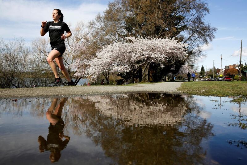 A woman jogs around Washington's Green Lake Park as social-distancing efforts continue to help slow the spread of coronavirus disease. Reuters