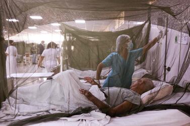 A nurse takes care of a dengue fever patient at a hospital near Lima, Peru. AFP