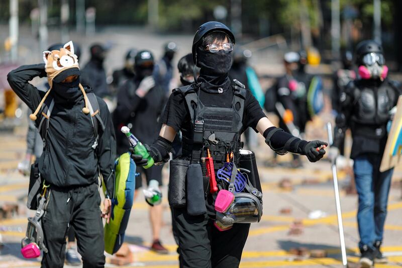 An anti-government protester holds a molotov cocktail alongside others on a road scattered with bricks outside the Polytechnic University in Hong Kong, China. Reuters