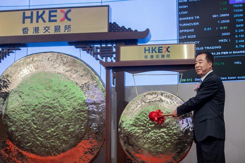 Tong Jilu, chairman of China Tower Corp., poses for photographs in front of a gong during the company's listing ceremony at the Hong Kong Stock Exchange in Hong Kong, China, on Wednesday, Aug. 8, 2018. China Tower inched up in Hong Kong trading debut after completing the world's largest initial public offering in two years. Photographer: Paul Yeung/Bloomberg