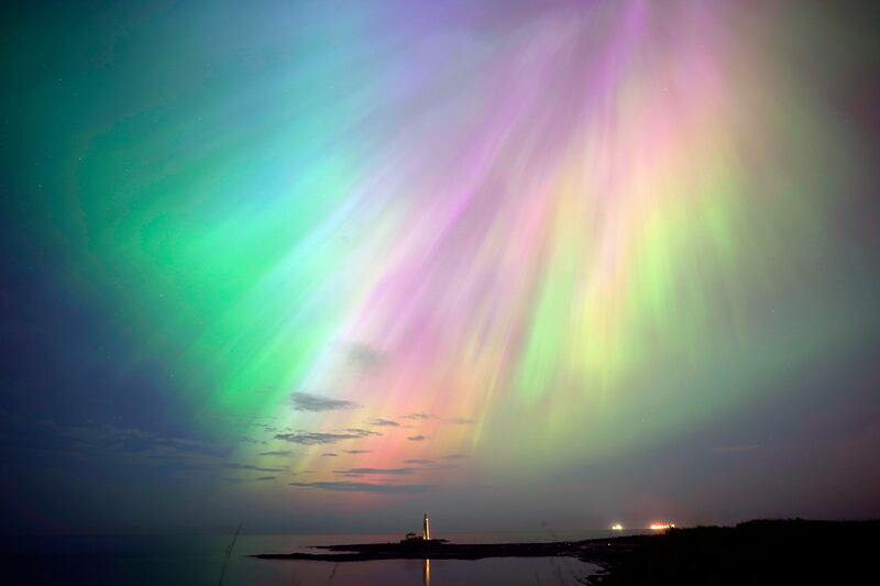The aurora borealis, known as the Northern Lights, shine over St Mary's Lighthouse in Whitley Bay, Tyne and Wear, northern England, on Friday May 10. PA 