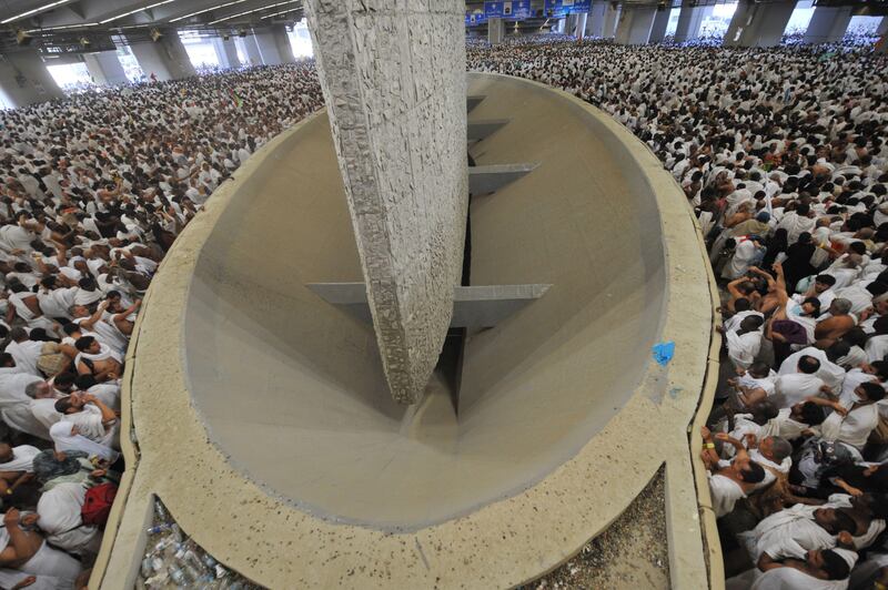 Muslim pilgrims throw pebbles at pillars during the "Jamarat" ritual, the stoning of Satan, in Mina near the holy city of Mecca, on November 6, 2011. Pilgrims pelted pillars symbolising the devil with pebbles to show their defiance on the third day of the hajj as Muslims worldwide marked the Eid al-Adha holy day with mass animal sacrifices.  AFP PHOTO/FAYEZ NURELDINE
 *** Local Caption ***  212239-01-08.jpg