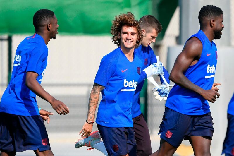 Barcelona's French forward Antoine Griezmann laughs as he runs alongside his new teammates. AFP
