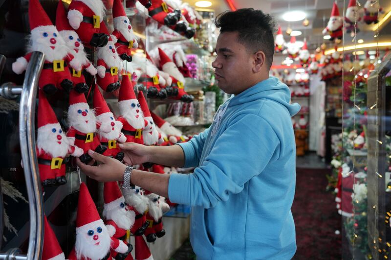 A Palestinian youth looks at Santa Claus dolls at a shop in Gaza city. AP