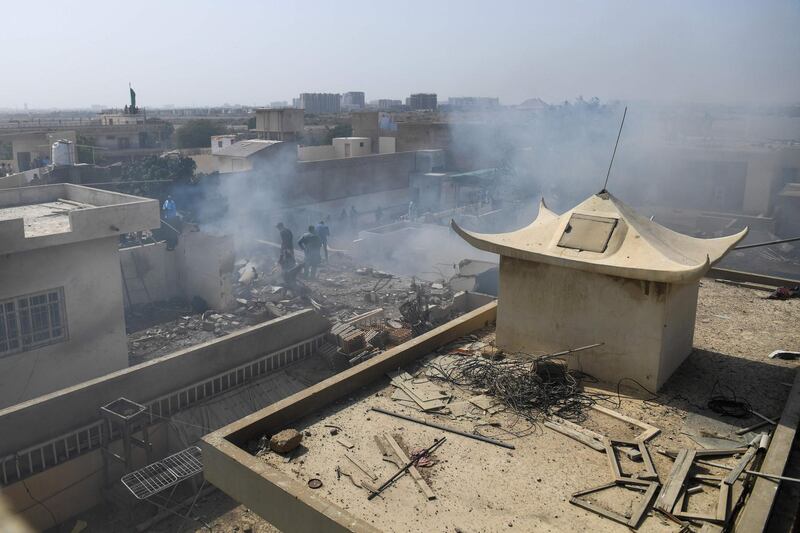 Rescue workers gather at the site after a Pakistan International Airlines flight crashed in a residential neighbourhood in Karachi on May 22, 2020. AFP