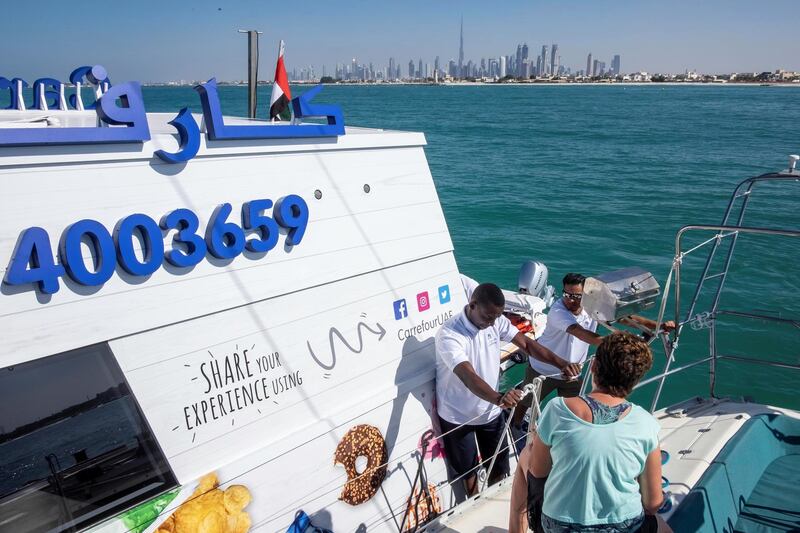 DUBAI, UNITED ARAB EMIRATES. 12 DECEMBER 2018. Trying out the new floating Carrefour mini market off the coast of Dubai. Dubai resident Marie Byrne takes her yacht out to try the new Carrefour floating shop. Maria comes alongside the floating shop, orders items and pays for them. (Photo: Antonie Robertson/The National) Journalist: Nicke Webster. Section: National.