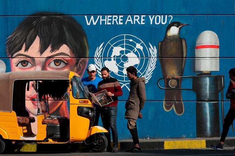 Protesters share a copy of the "Tuk-Tuk" newspaper in Tahrir Square. AP Photo