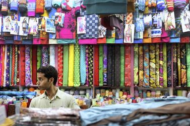 A man arranges fabric at a store in Satwa in Duba. many such stores are family run businesses that have been passed down generations. Francois Nel/Getty