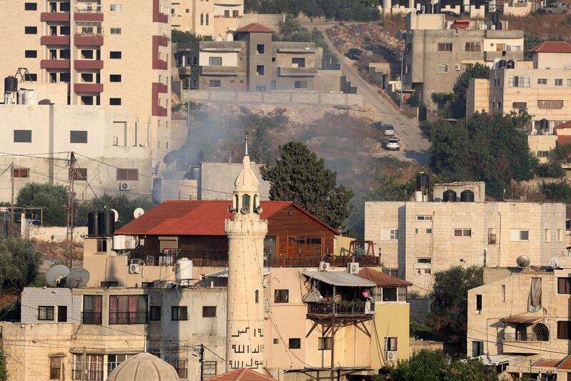 Smoke billows from houses inside a refugee camp adjacent to Jenin after an Israeli strike. AFP