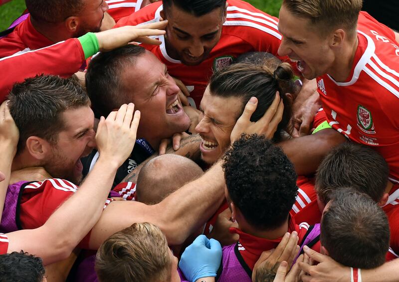 Wales forward Gareth Bale is mobbed after scoring during the Euro 2016 match against Slovakia  at the Stade de Bordeaux in July 2016. AFP