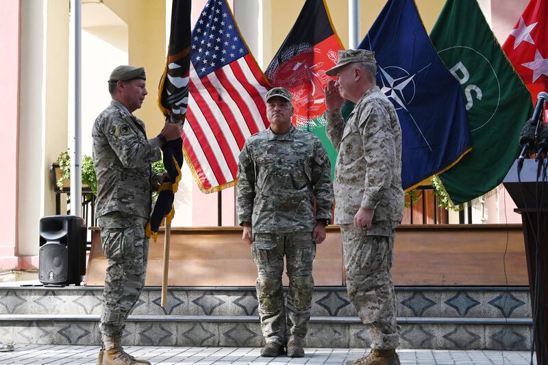 General Kenneth McKenzie, the head of US Central Command, salutes as he receives the flag of US-led Resolute Support mission from US top commander of coalition forces in Afghanistan, General Austin "Scott" Miller, during an official handover ceremony at the Resolute Support headquarters in the Green Zone in Kabul on July 12, 2021. AFP