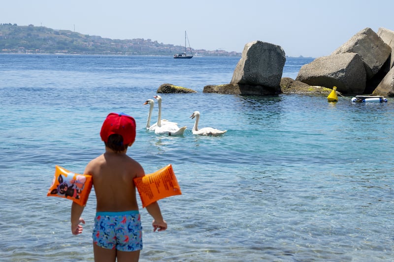 Swanning about in the sun is child's play, near Messina in Sicily. AFP