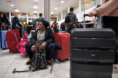 Passengers sit with their luggage in the South Terminal building at London Gatwick Airport, south of London, on December 21, 2018, as flights started to resume following the closing of the airfield due to a drone sightings. AFP