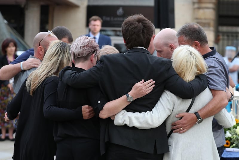 Family members of the three victims comfort each other after lighting candles during a vigil for the victims of the Reading terror attack, at Market Place on June 27, 2020 in Reading, United Kingdom. Getty Images