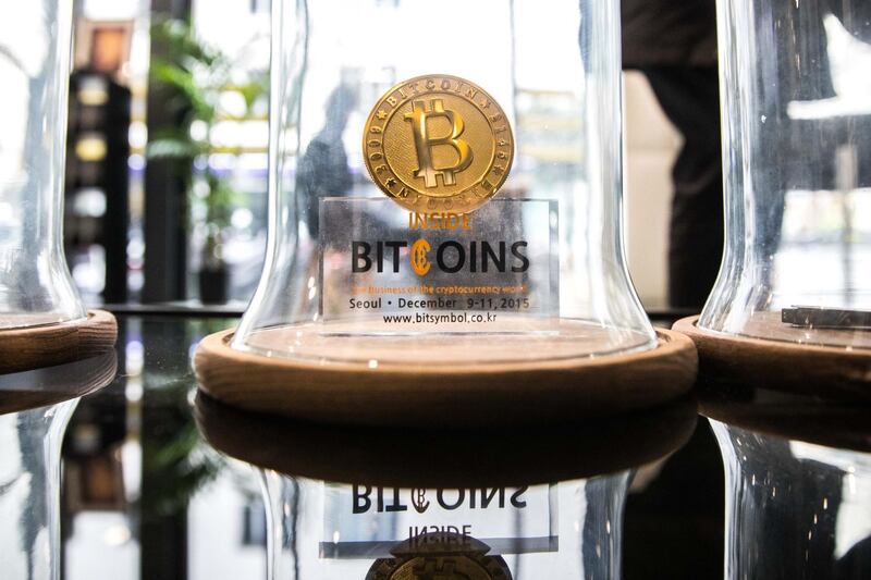 FILE: A gold colored bitcoin token sits on display under a glass cloche inside the offices of La Maison du Bitcoin bank in Paris, France, on Thursday, Nov. 23, 2017. Bitcoin is showing no signs of slowing down, the price of the largest cryptocurrency by market value is soaring as it gains greater mainstream attention despite warnings of a bubble in what not everyone agrees is an asset. Our editors select the best archive images on Bitcoin. Photographer: Christophe Morin/Bloomberg